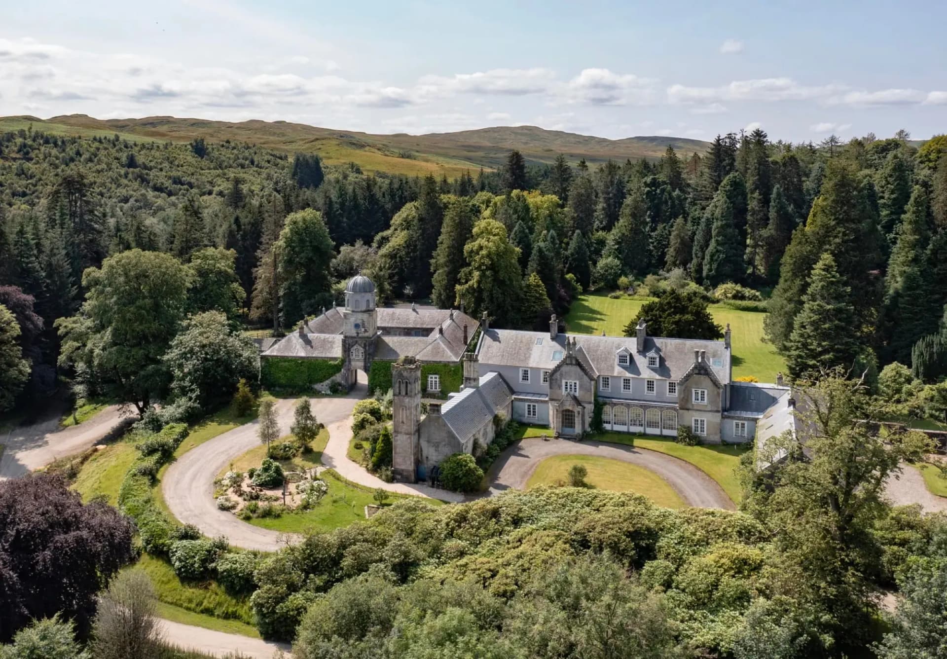 Craigengillan House seen from the air, wrapped in woodland